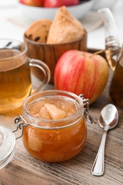 Delicious apple jam in jar on wooden table