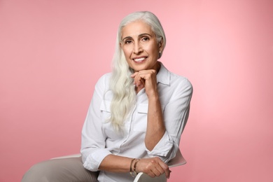 Photo of Portrait of beautiful mature woman on pink background