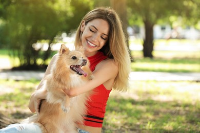 Photo of Young woman with her cute dog in park