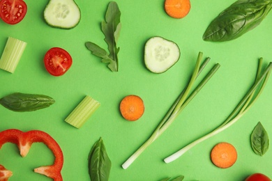 Photo of Flat lay composition with fresh ingredients for salad on green background