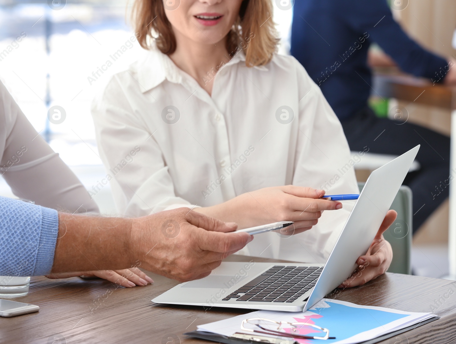 Photo of Female manager consulting mature couple in office