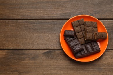 Photo of Orange plate with delicious and healthy hematogen on wooden table, top view. Space for text