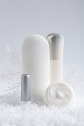 Photo of Set of cosmetic products and decorative snow on white background. Winter care