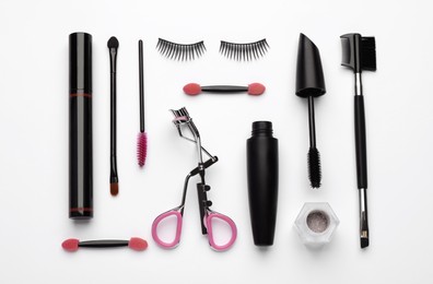 Photo of Composition with eyelash curler, makeup products and accessories on white background, top view