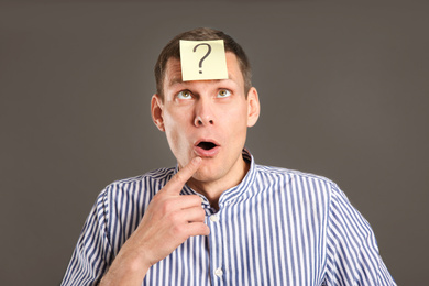 Photo of Emotional man with question mark on grey background