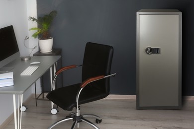 Image of Big steel safe with electronic lock near workplace indoors