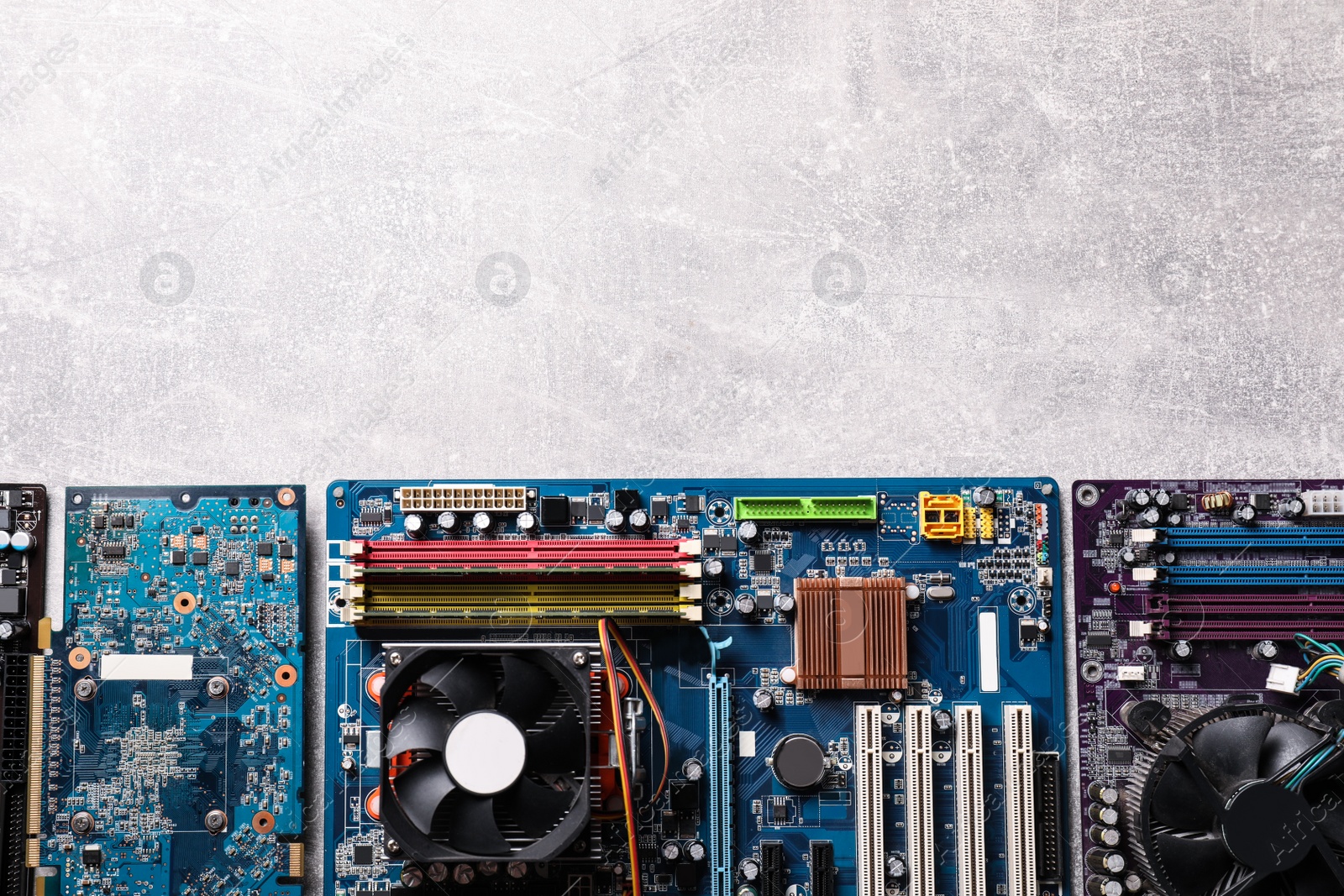 Photo of Computer motherboards on light grey table, flat lay with space for text. Electronic device