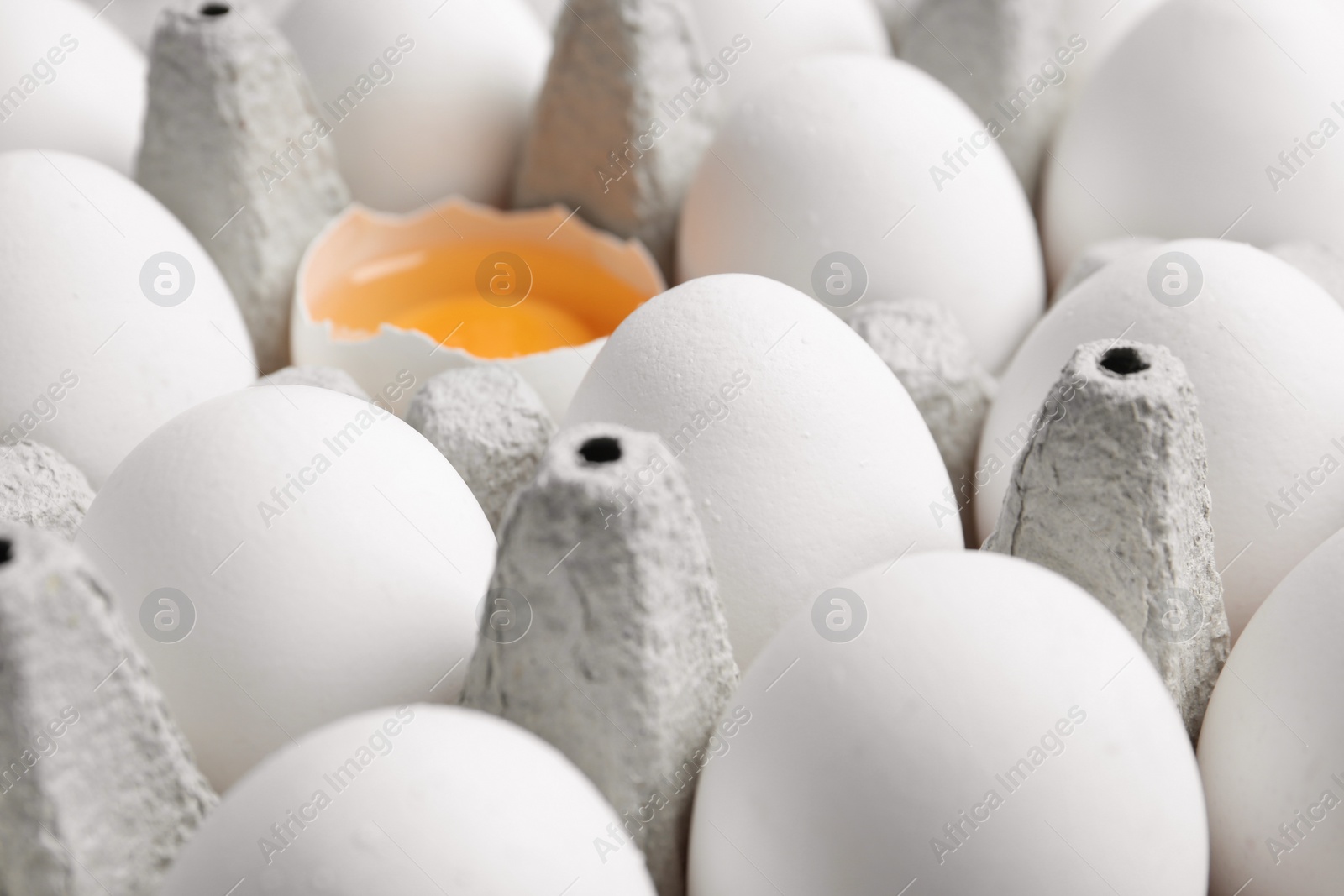 Photo of Many fresh raw chicken eggs in cartons as background, closeup