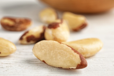 Photo of Tasty Brazil nuts on white table, closeup