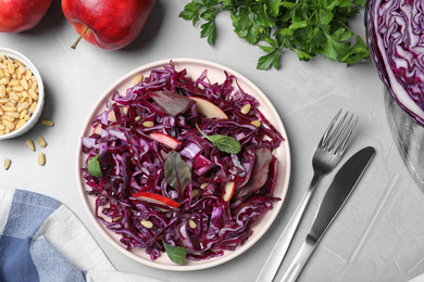 Photo of Fresh red cabbage salad served on light grey table, flat lay