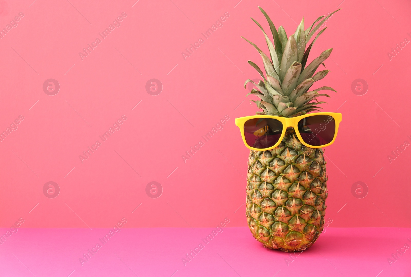 Photo of Fresh ripe pineapple with sunglasses on color background