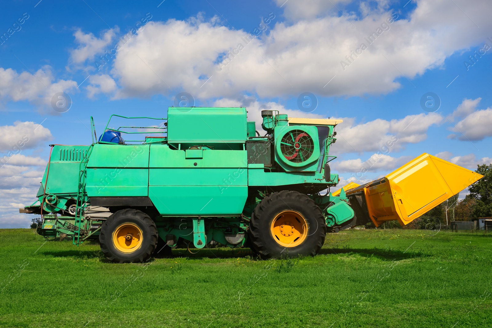 Photo of Modern combine harvester on green lawn with fresh grass