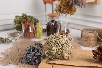 Photo of Many different dry herbs and flowers on white table