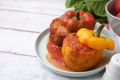 Photo of Delicious stuffed bell peppers on white wooden table, closeup. Space for text