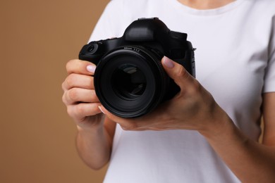 Photo of Photographer with camera on brown background, closeup