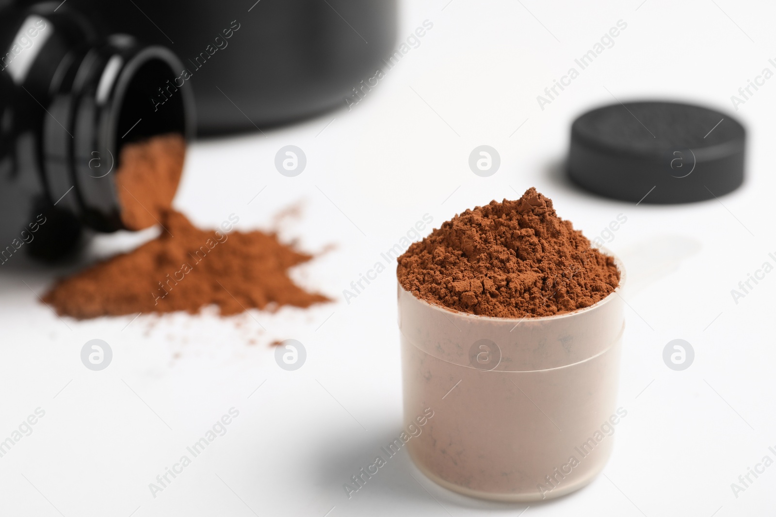 Photo of Measuring scoop with protein powder on table. Space for text