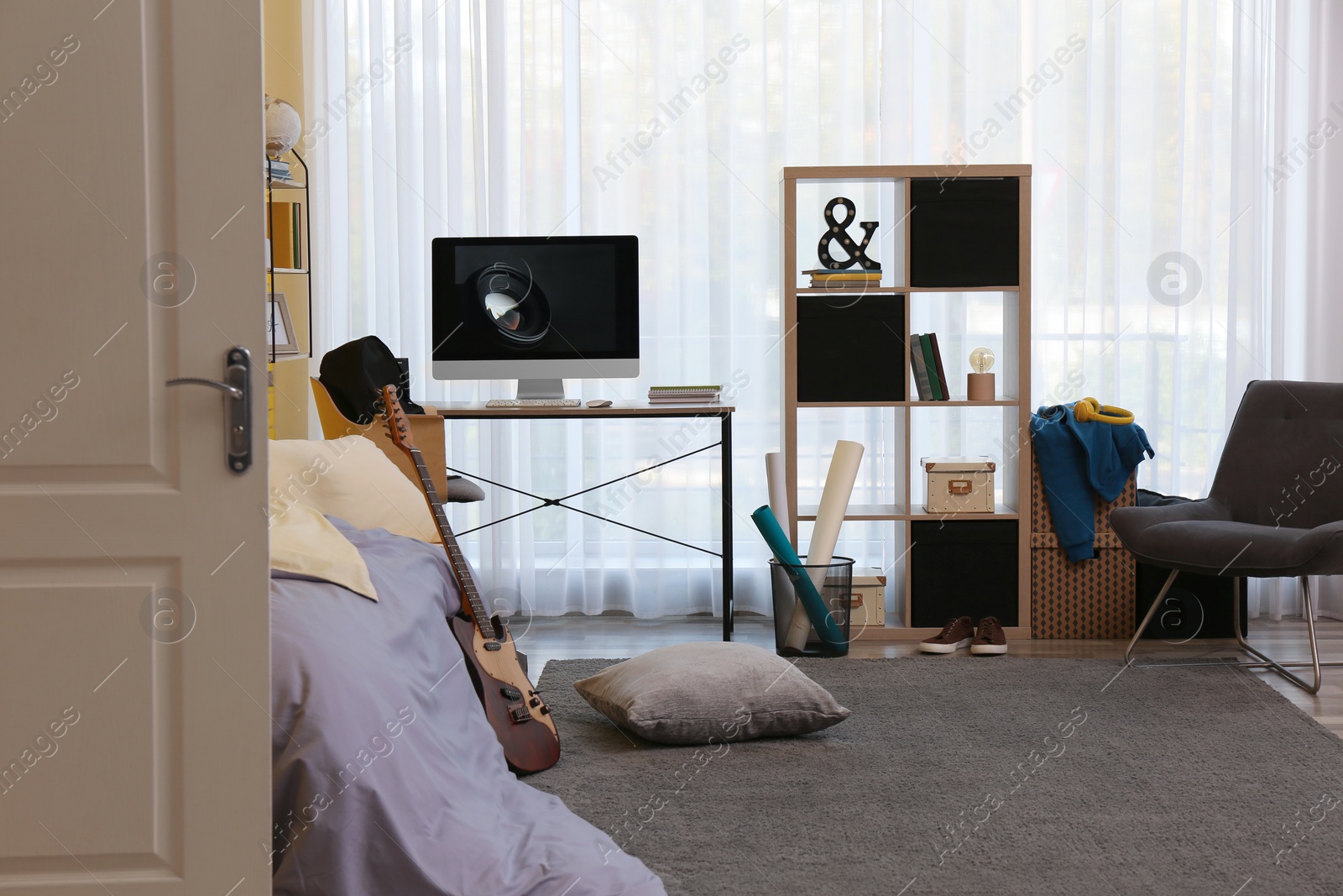 Photo of Stylish teenager's room interior with computer and bed