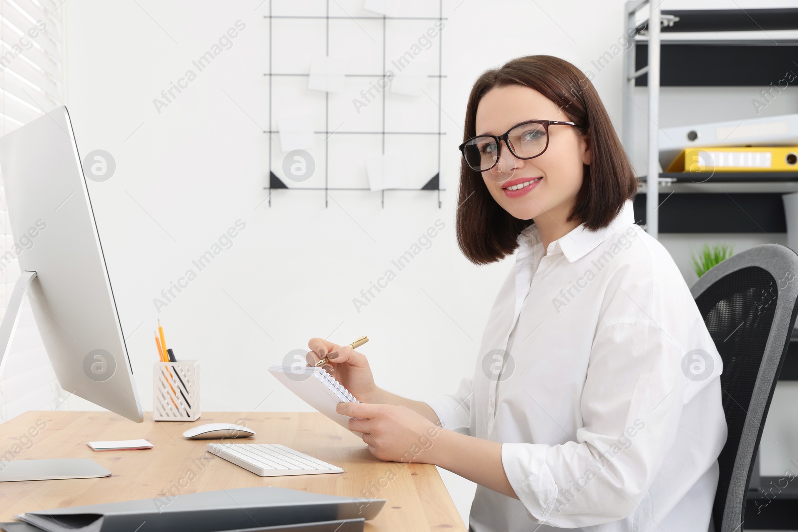 Photo of Happy young intern working at table in modern office