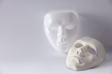 Plastic face masks on white background, space for text. Theatrical performance