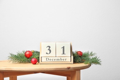 Wooden block calendar and festive decor on table. Christmas countdown