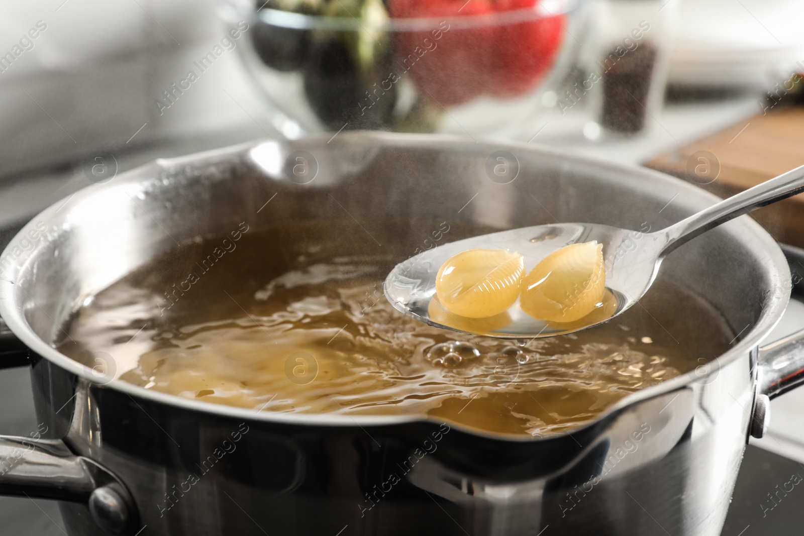 Photo of Cooking pasta in pot on stove, closeup view