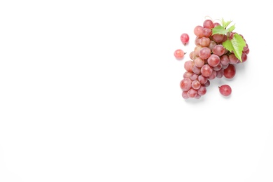 Photo of Bunch of ripe red grapes with green leaves on white background, top view