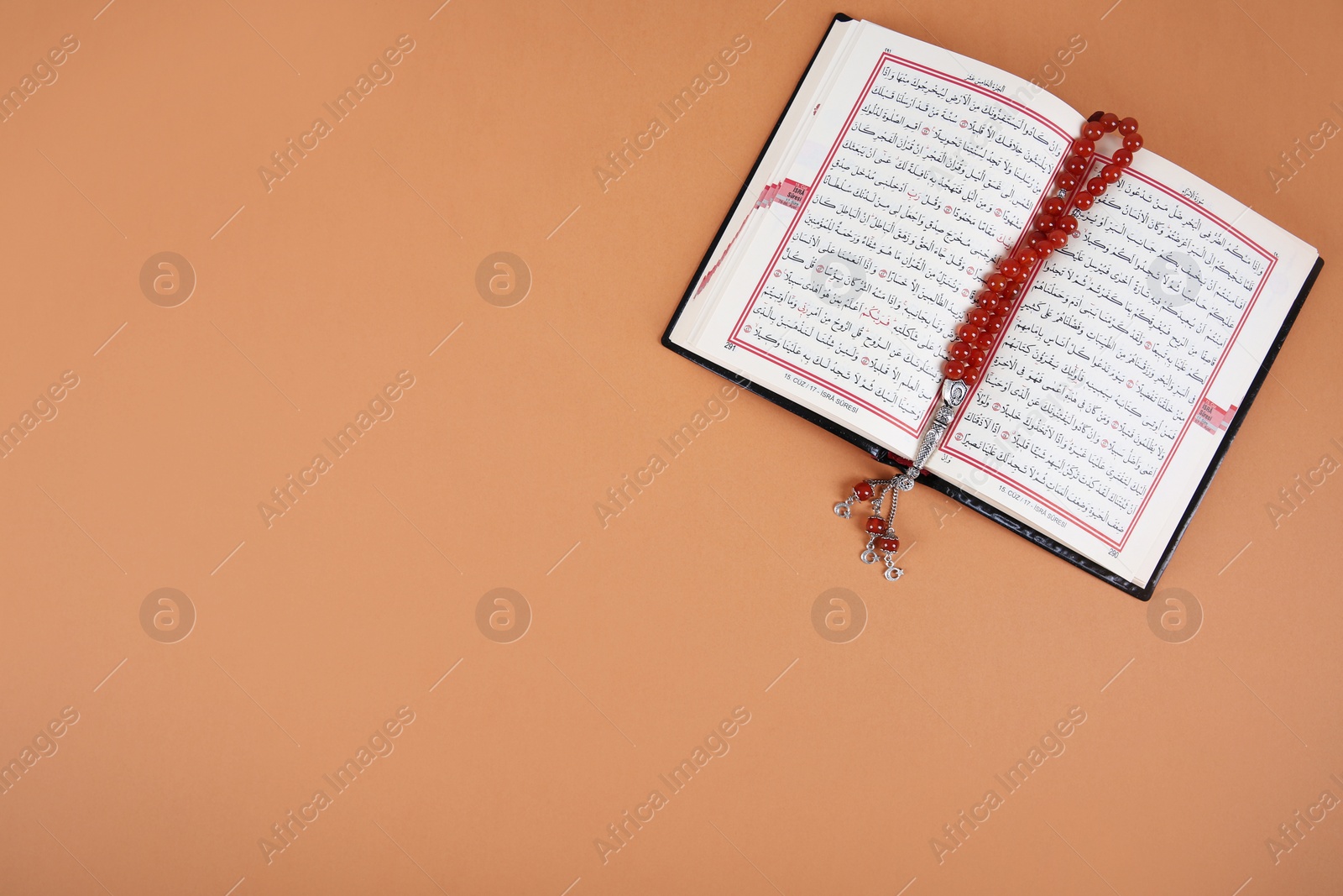 Photo of Muslim prayer beads, Quran and space for text on color background, top view