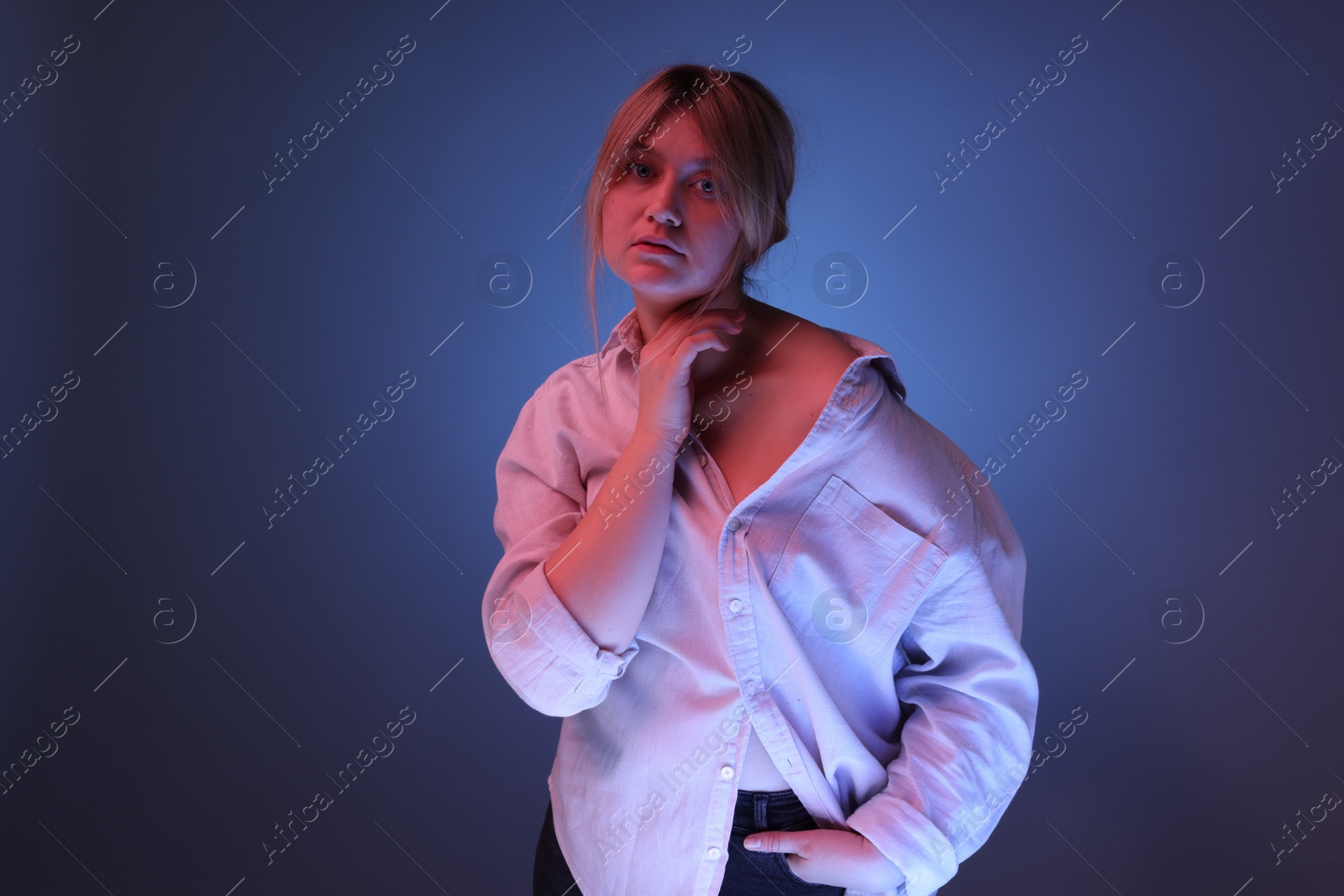 Photo of Portrait of beautiful young woman on color background with neon lights