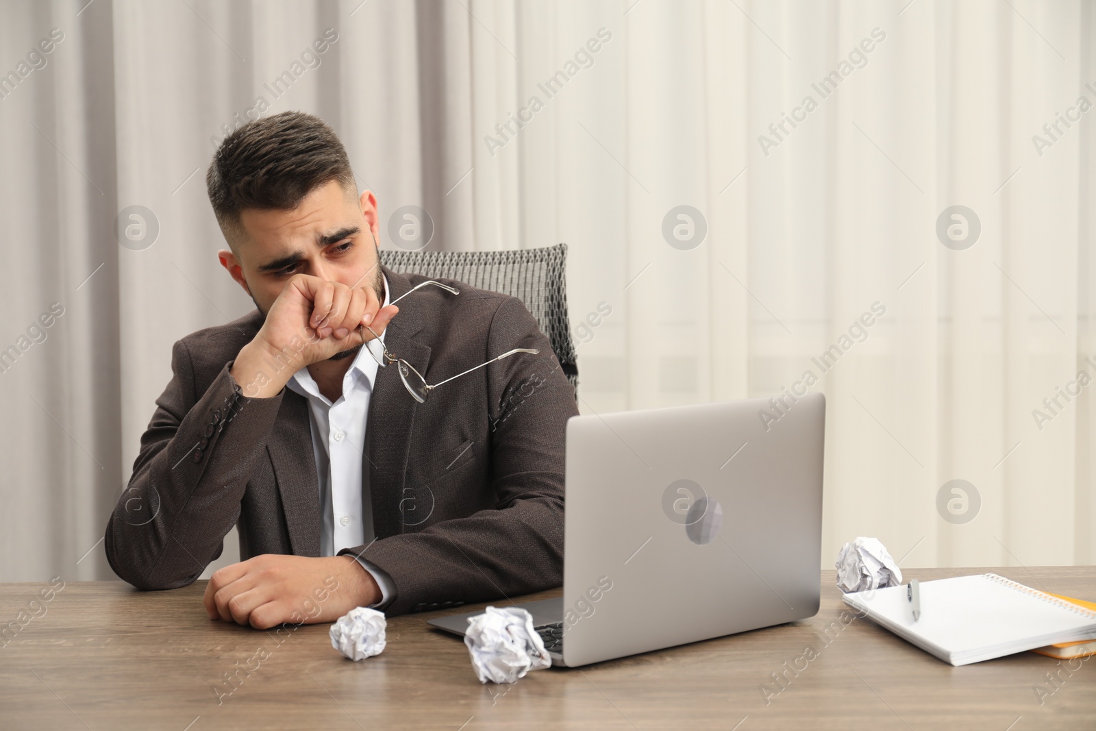 Photo of Sad businessman sitting at table in office