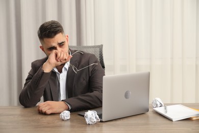 Photo of Sad businessman sitting at table in office