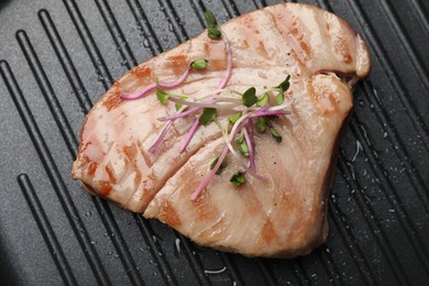 Photo of Delicious tuna steak with microgreens in grill pan, top view