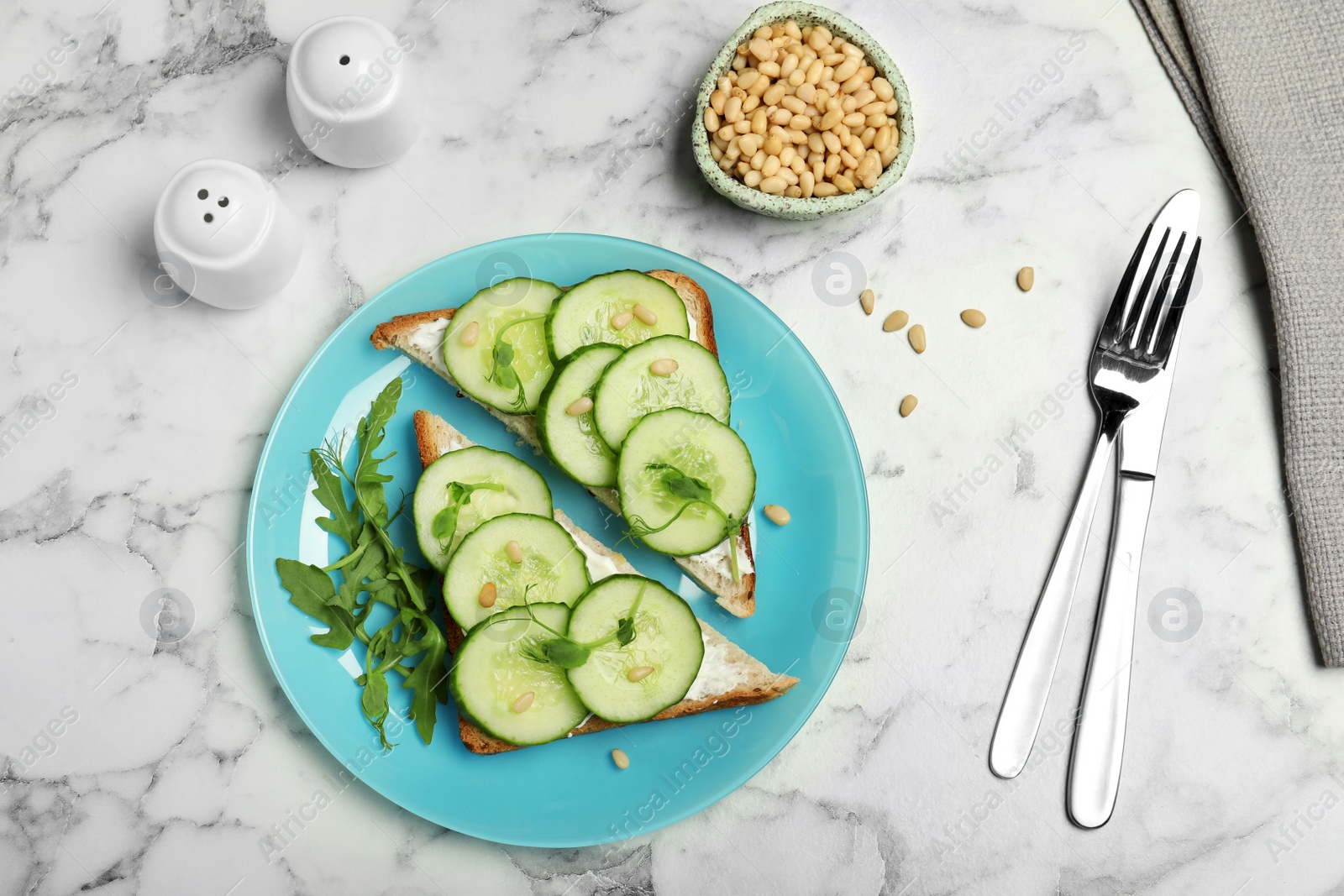 Photo of Flat lay composition with traditional English cucumber sandwiches and pine nuts on marble table