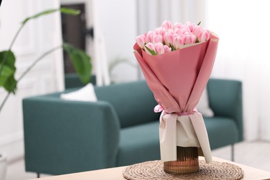 Beautiful bouquet of fresh pink tulips on table at home