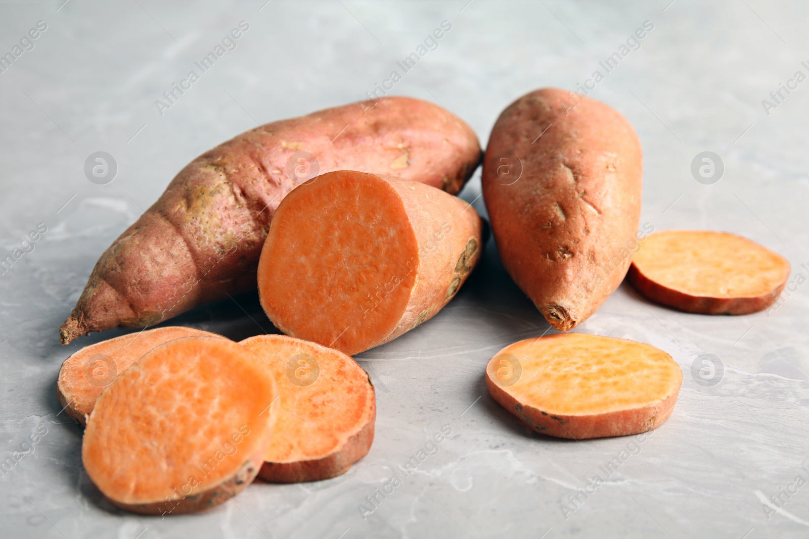 Photo of Composition with sweet potatoes on grey background