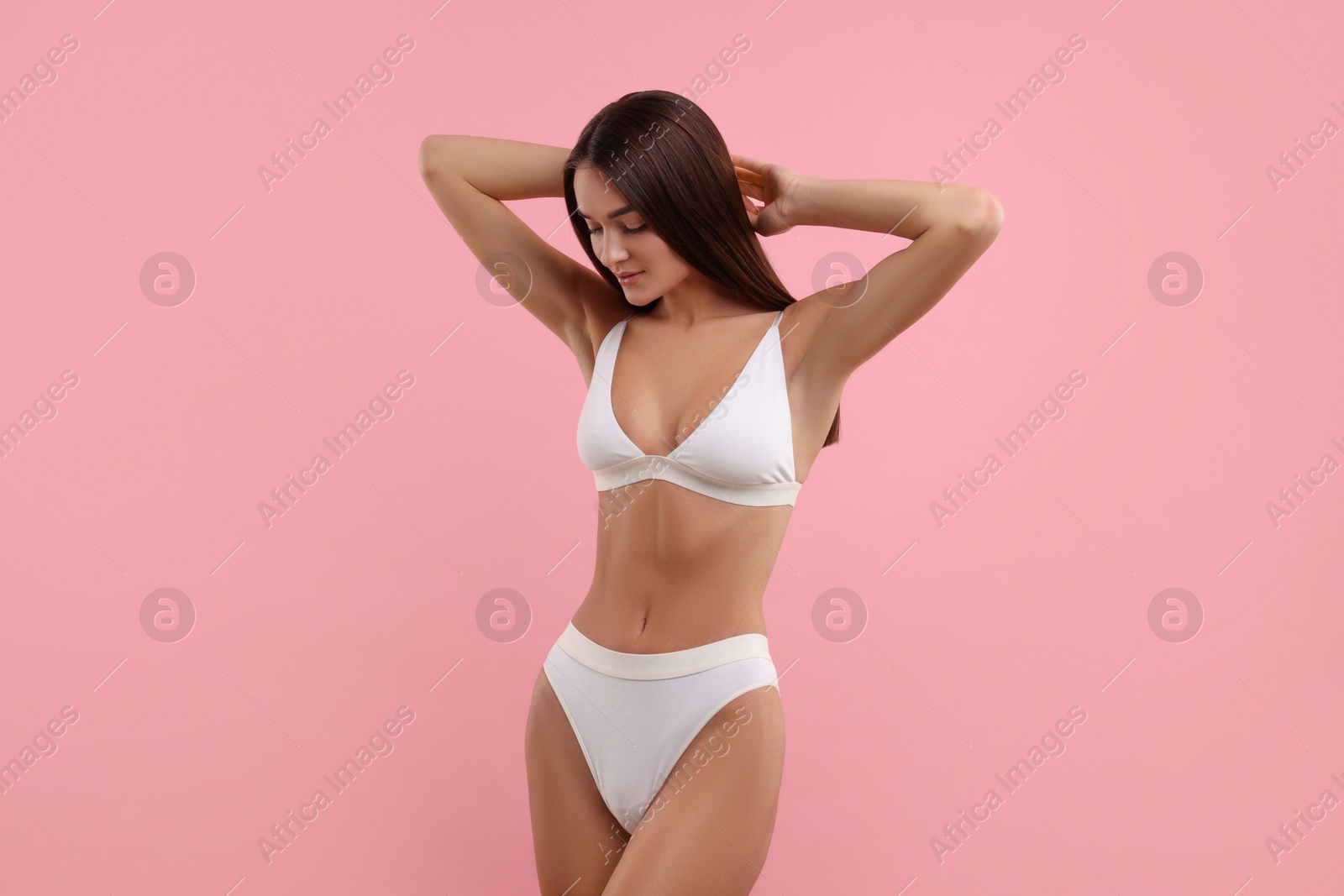 Photo of Young woman in stylish white bikini on pink background