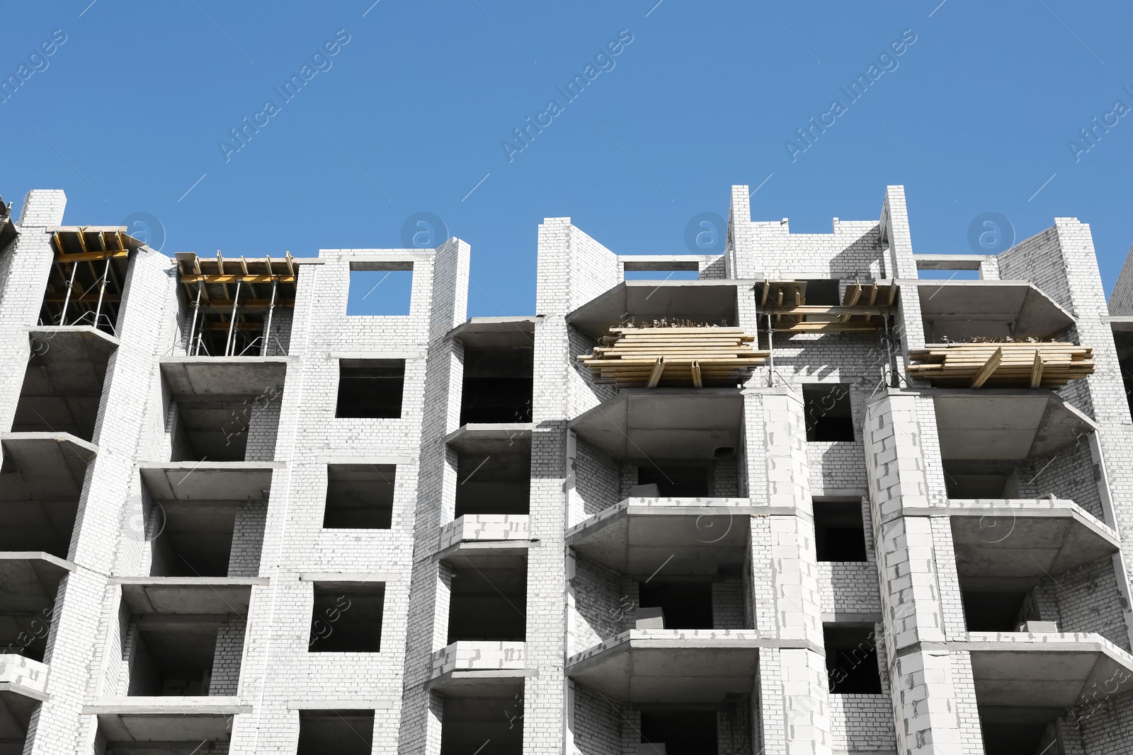 Photo of Construction site with unfinished building on sunny day, low angle view