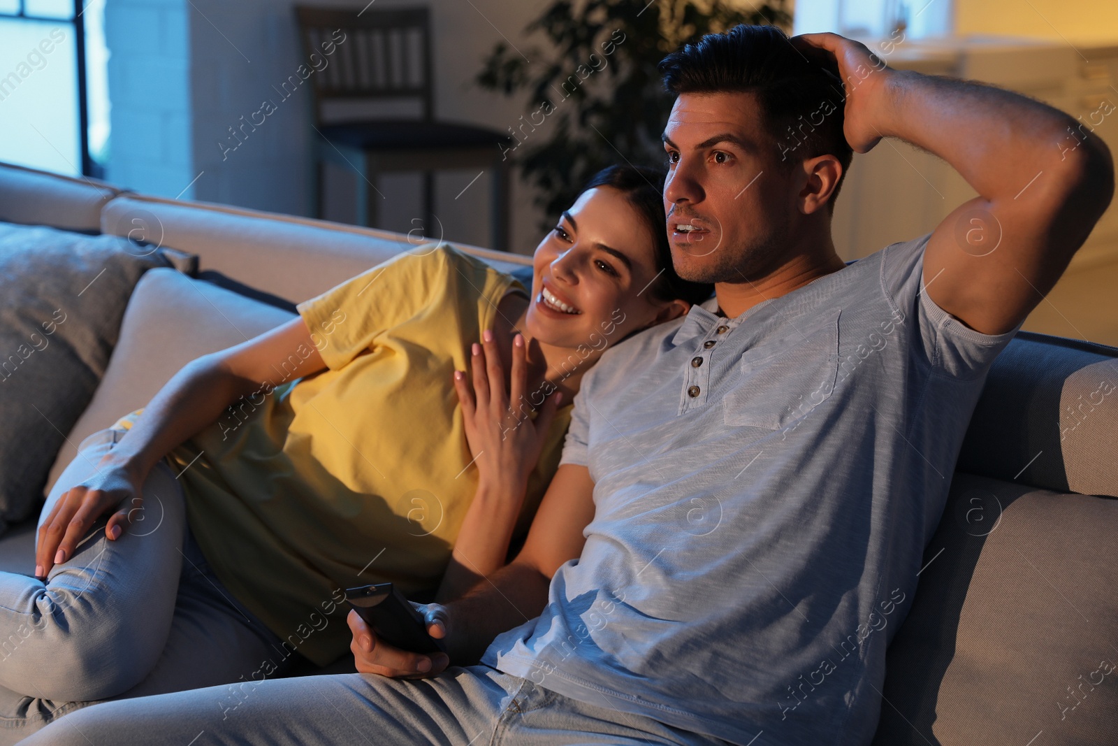 Photo of Couple watching movie on sofa at night