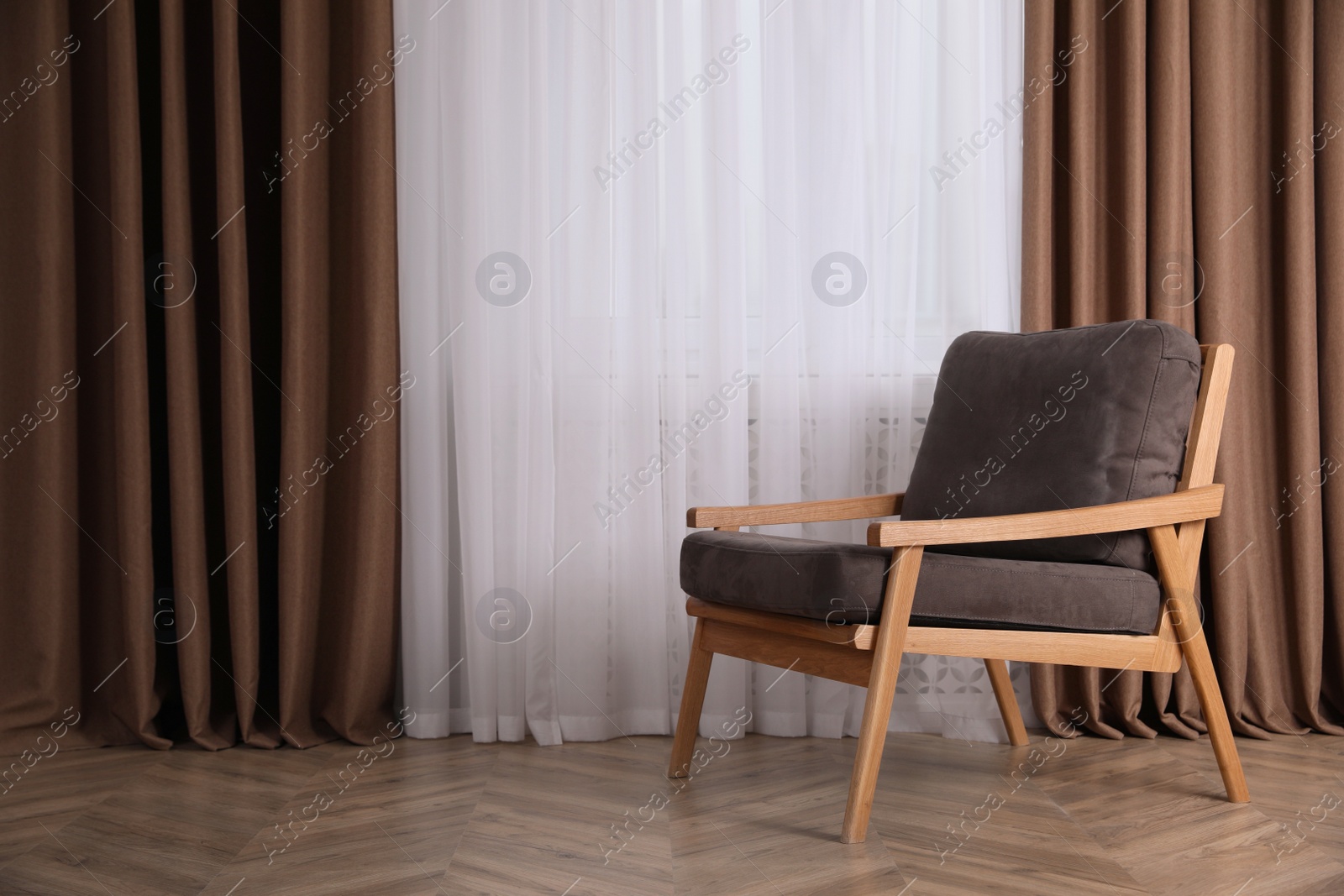 Photo of Comfortable armchair near window indoors, space for text. Interior design