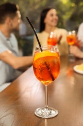 Friends spending time together at cafe, focus on Aperol spritz cocktail