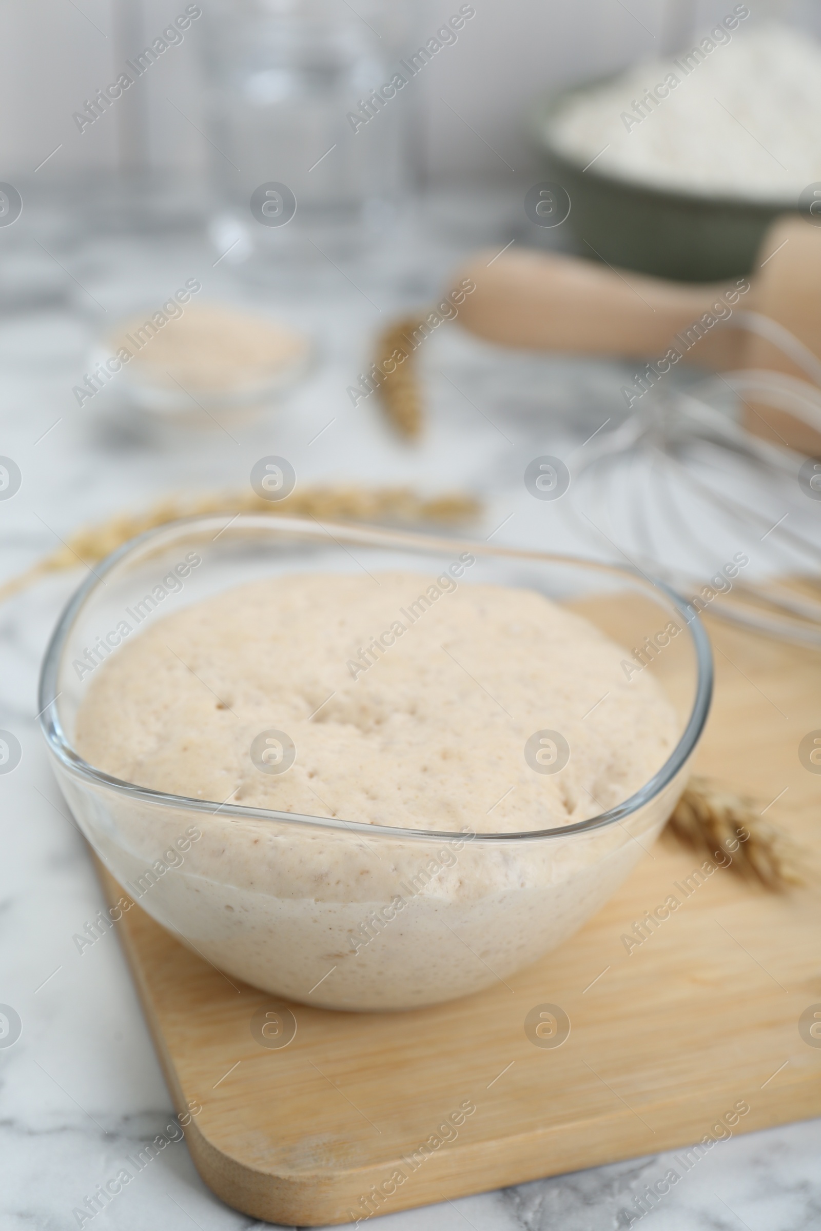 Photo of Leaven and ear of wheat on white marble table