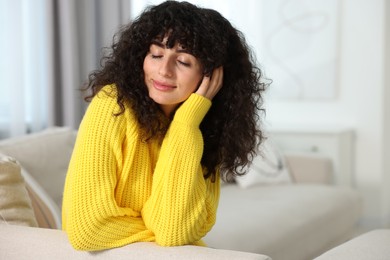 Photo of Young woman in stylish yellow sweater indoors, space for text