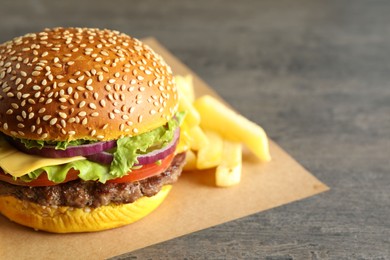 Photo of Burger with delicious patty and french fries on table, closeup