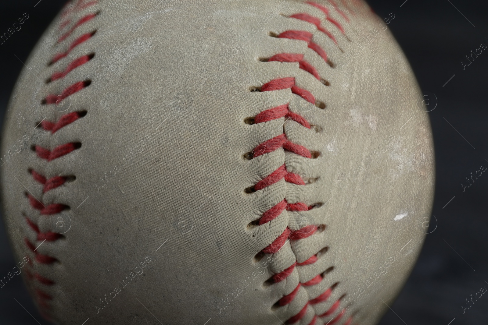 Image of Worn baseball ball on black background, closeup