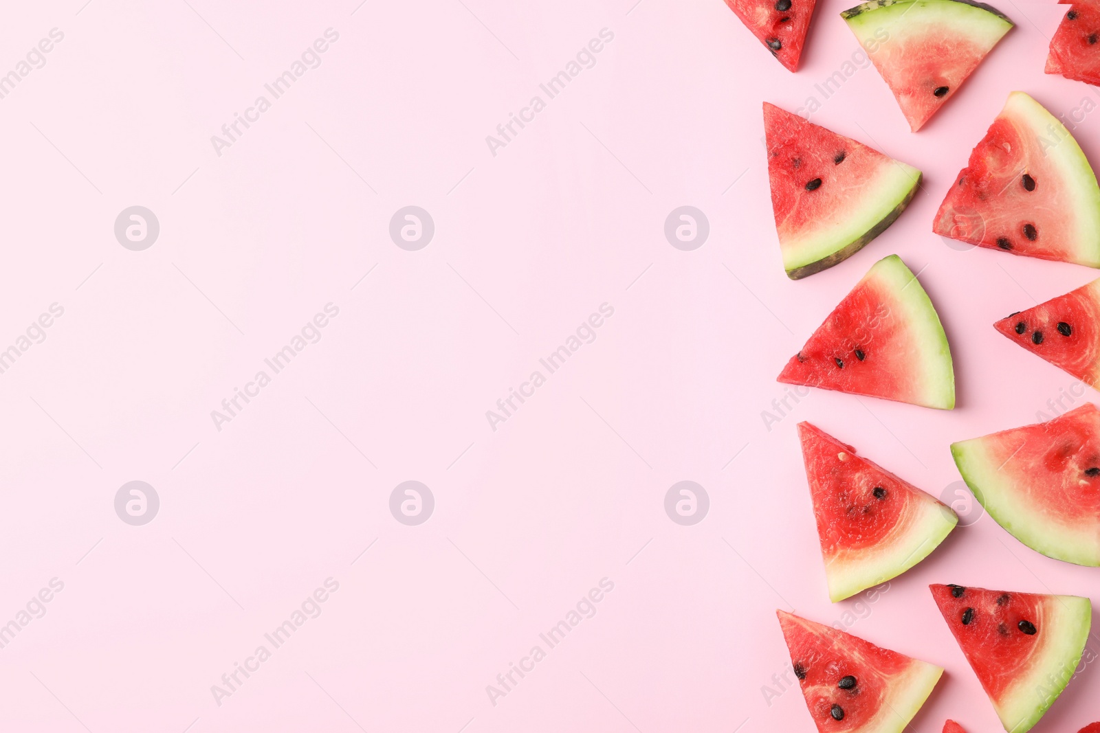 Photo of Slices of ripe watermelon on color background, top view with space for text