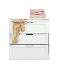 Modern wooden chest of drawers with clothes on white background