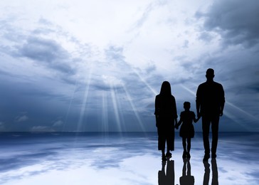 Image of Silhouettes of godparents with child and beautiful view of sky with grey clouds, space for text