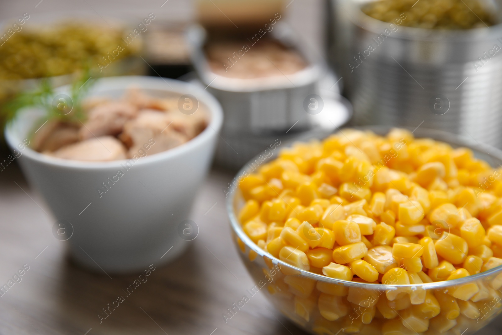 Photo of Glass bowl of corn and canned products, closeup. Space for text