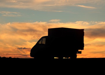 Image of Truck parked on country road at sunset