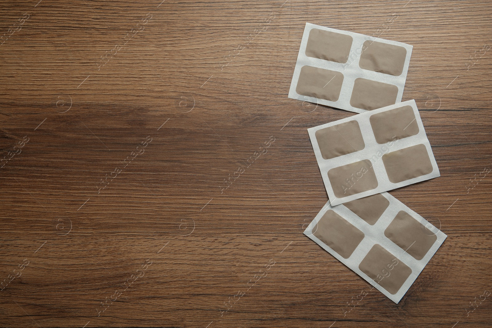 Photo of Mustard plasters on wooden table, flat lay. Space for text