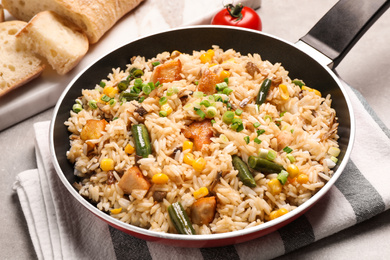 Delicious rice pilaf with vegetables on table